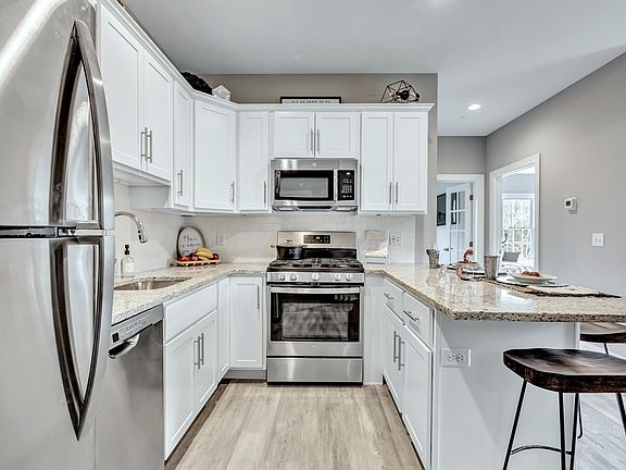 Kitchen includes stainless appliances, gas stove, dishwasher, and granite countertops.