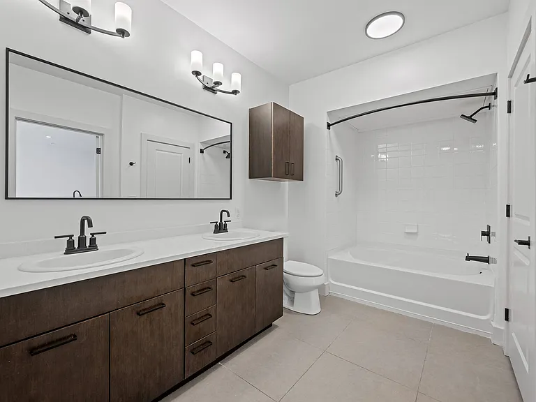 Spacious Bathroom Featuring Dual Sinks and Shower/Tub Combo
