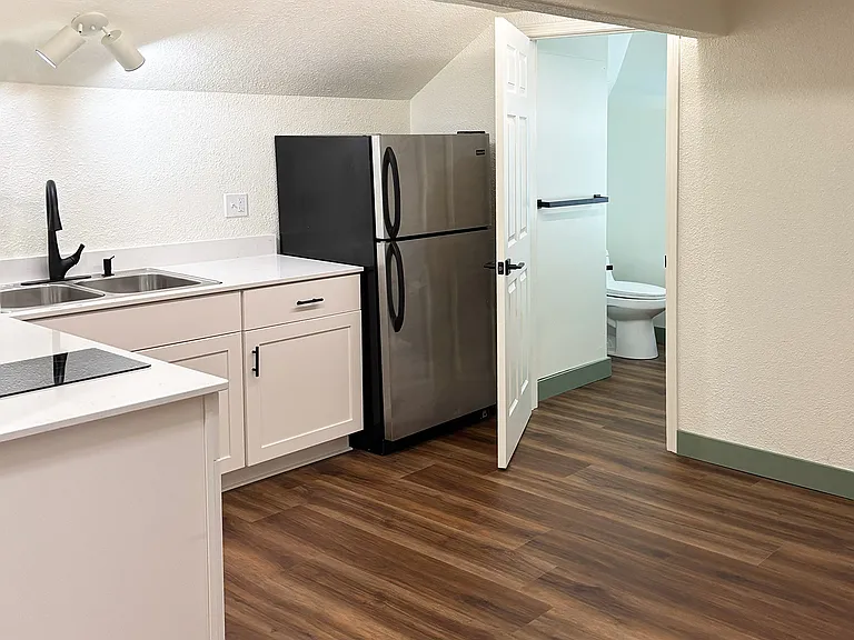Kitchen area with view of bathroom entry.