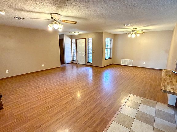 Large oversized living area with wood like flooring & dining area.