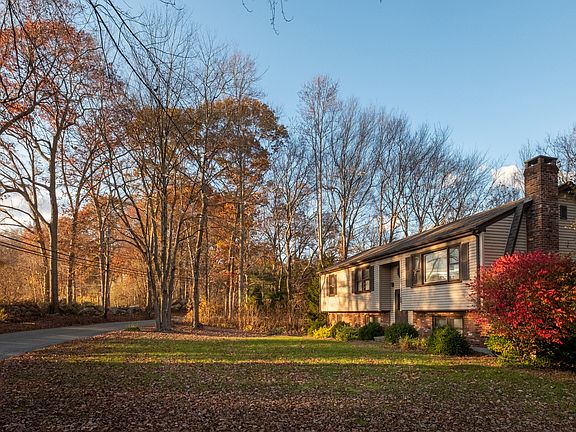 View of large, lightly wooded front yard.