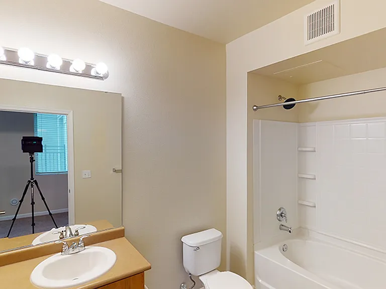 Apartment bathroom with large soaking tub and tile flooring.