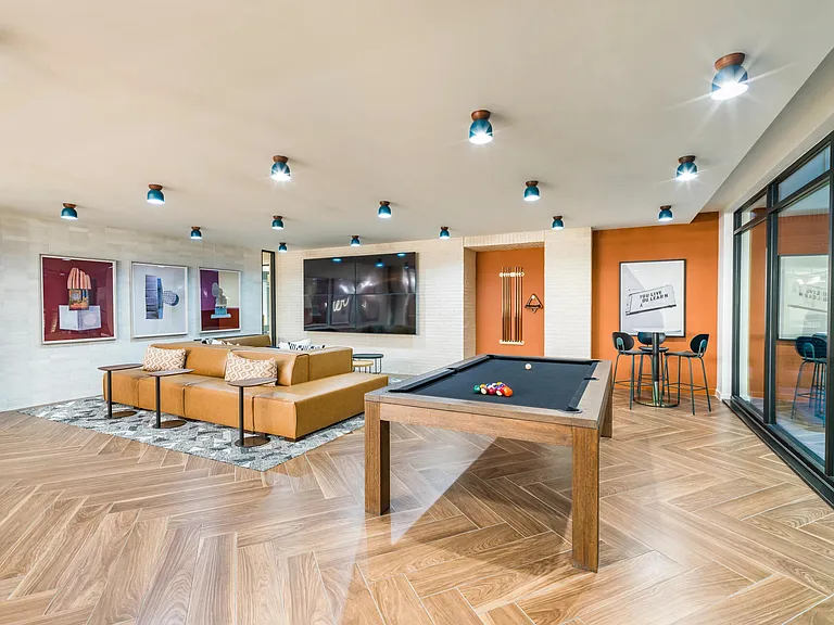 Experience leisure at Modera EaDo's clubhouse, featuring versatile gathering spaces and dynamic gaming areas for endless fun.