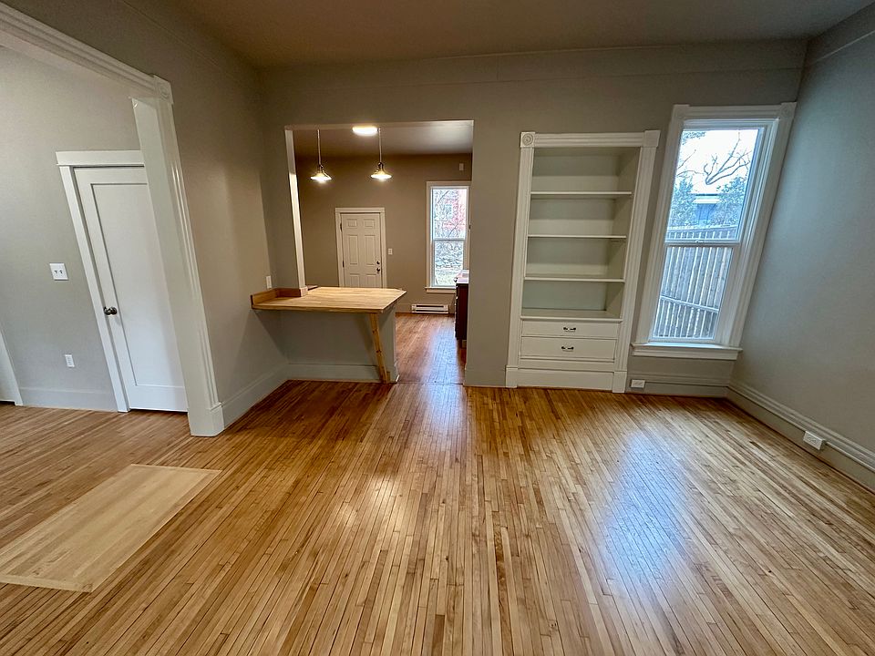 Living room, looking into kitchen. Large work station, built-in cabinets, two closets, maple floors. New windows throughout. Entire building has been rewired with ample lights and outlets.