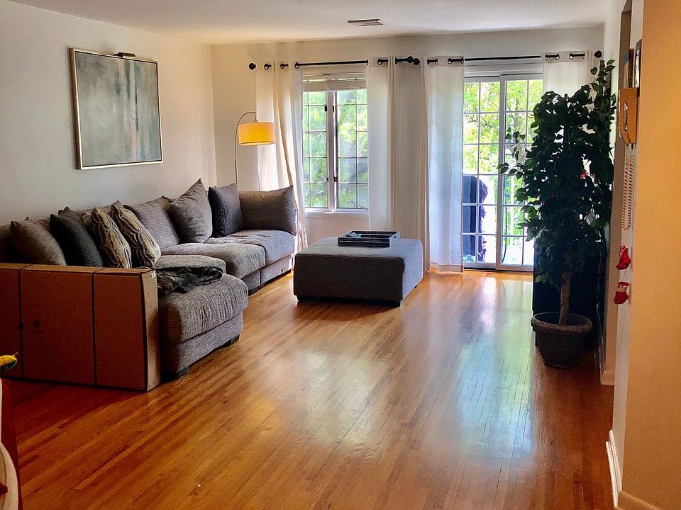 Open living room with private balcony, hardwood floors throughout apartment.