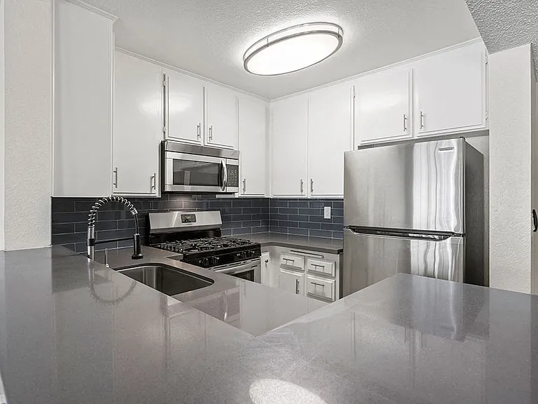 Kitchen with stainless steel oven, microwave, and fridge.