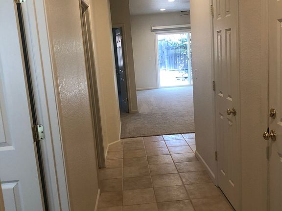 Front entry hall looking into the unit. One bedroom on the left, followed by the hall bathroom. On the right is the garage entry and a hall closet.