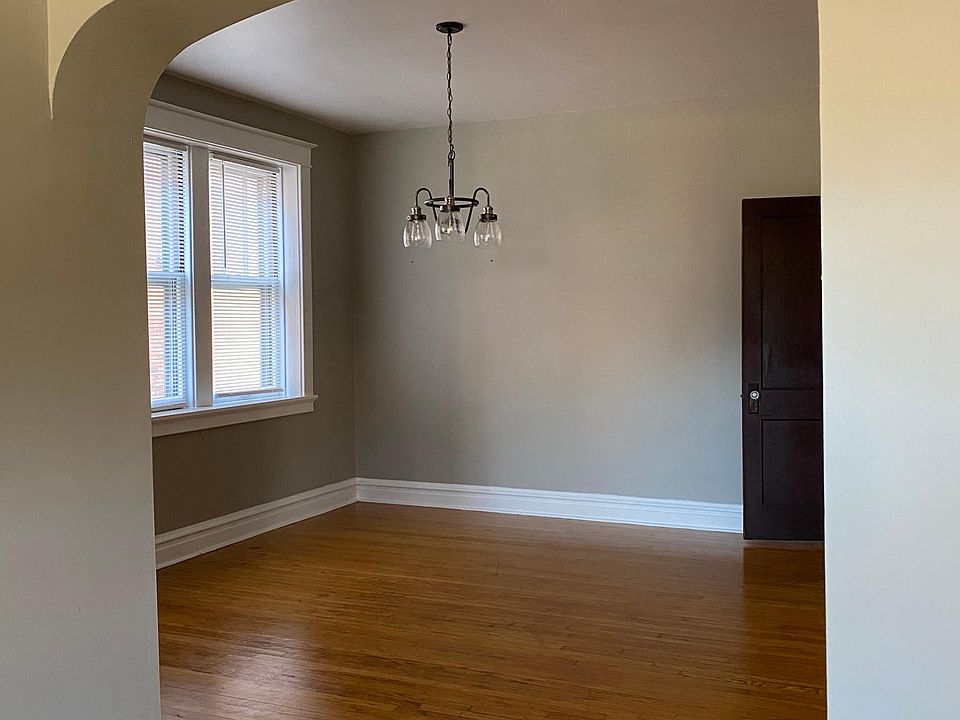 Archway leading from living room into dining area. Triple width window and new pendant light add to open bright space.