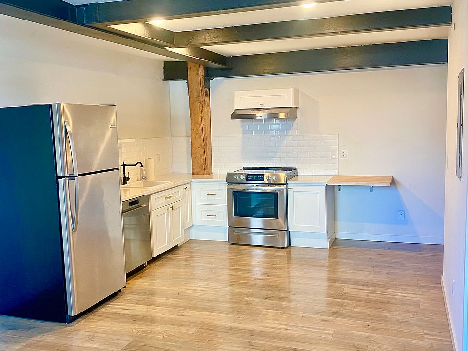 Kitchen featuring Quartz and butcher block counters, 100 year old post and metal beams