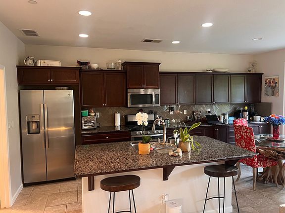kitchen and island, showing cabinets and stainless steel appliances
The laundry room w/ washer/dryer is to the far left