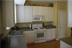Bright and cheery kitchen with plenty of cabinets for storage!