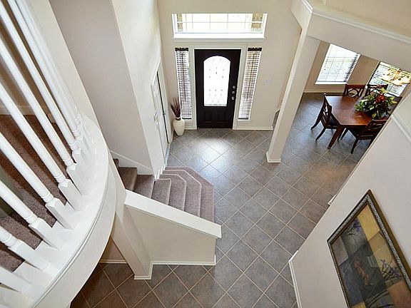  A view of the gorgeous foyer from upstairs. Grand entry with unique staircase and view of the upstairs.