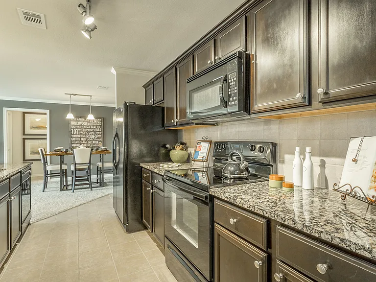 Beautiful kitchen with black energy efficient appliances and granite countertops at Amberleigh Ridge