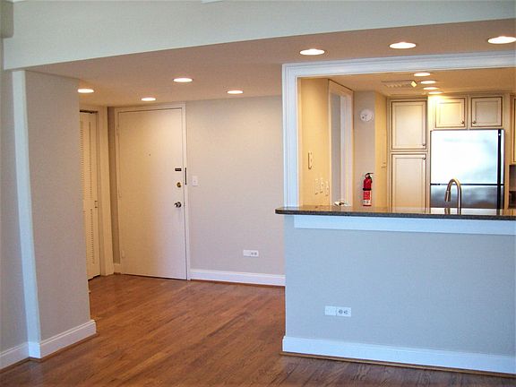 Entrance door with kitchen on the right. a large utility closet is to the left of the entrance door.