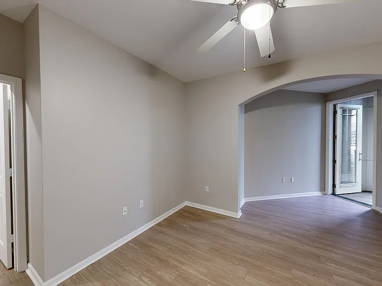 Spacious apartment bedroom with large closet and wood-style flooring.