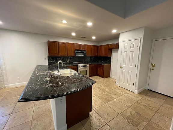 Bright kitchen w/ stainless steel sink and faucet, and dedicated pantry.