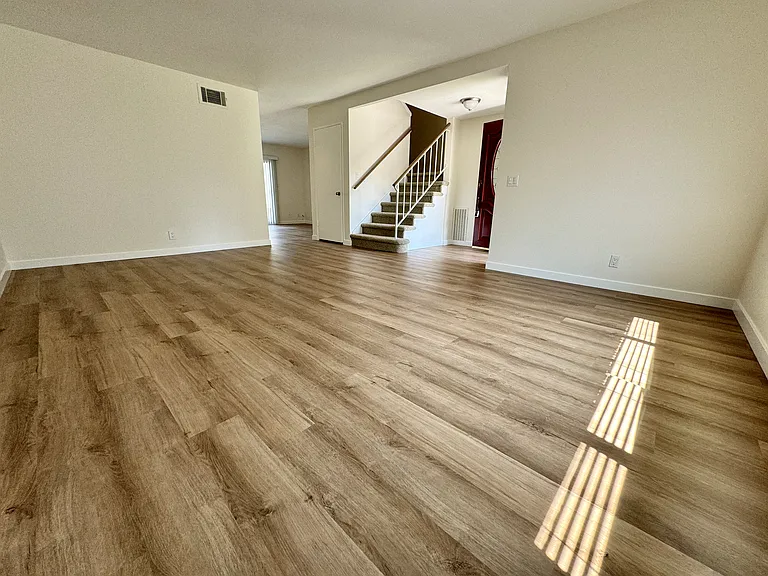 Spacious living room with an abundance of lights boast new vinyl plank flooring and new paint!