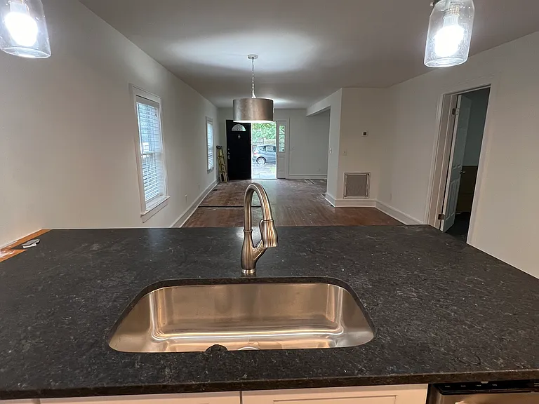 Looking from the kitchen through the dining area to the front door. Master bedroom is door to the right and living room is the large opening further down on the right.