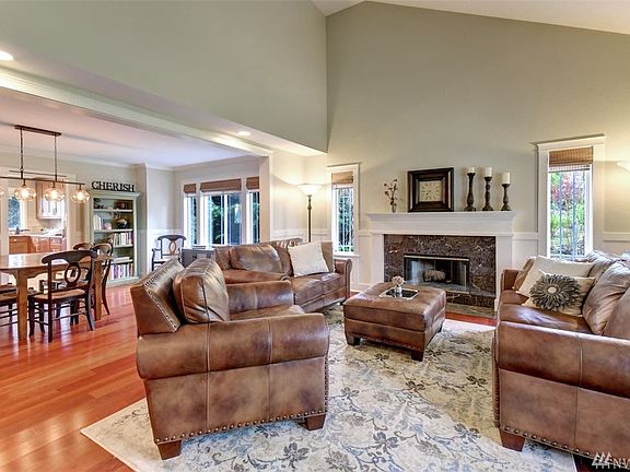Living room with soaring celings, wood burning fireplace and mantel. Wood wrapped windows throughout the home.