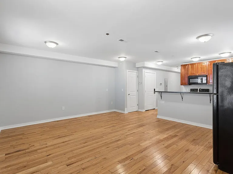 Open-concept living area with hardwood floors and a convenient breakfast bar, connecting to the kitchen with ample cabinetry.