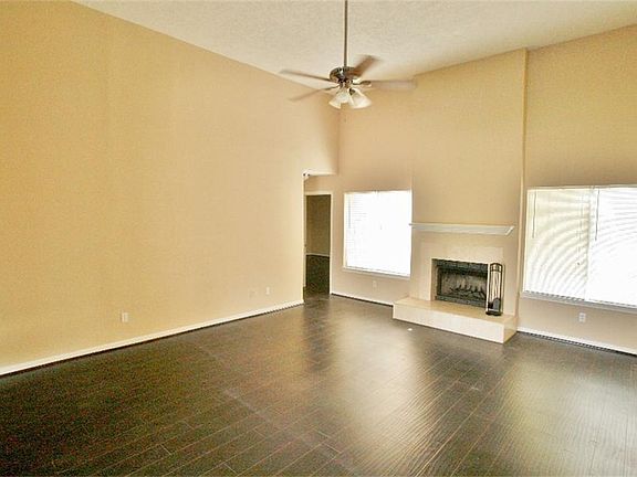 Large Living Room with wood burning firelplace and rich wood laminate floors