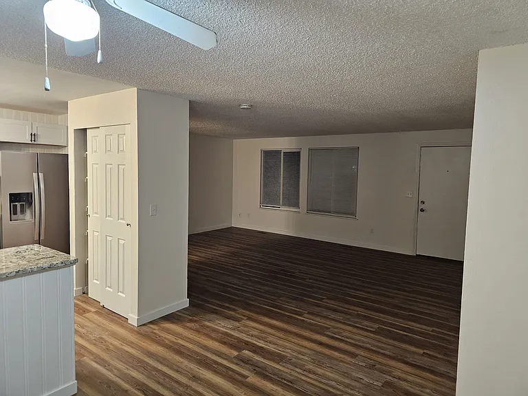 View of living area from dining room. Has new laminate floors, new paint, new lights. Home comes with new blinds throughout.