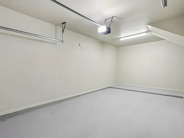 Spacious, clean garage with smooth flooring and bright overhead lighting, perfect for parking or storage. Spacious, clean garage with smooth flooring and bright overhead lighting, perfect for parking or storage.