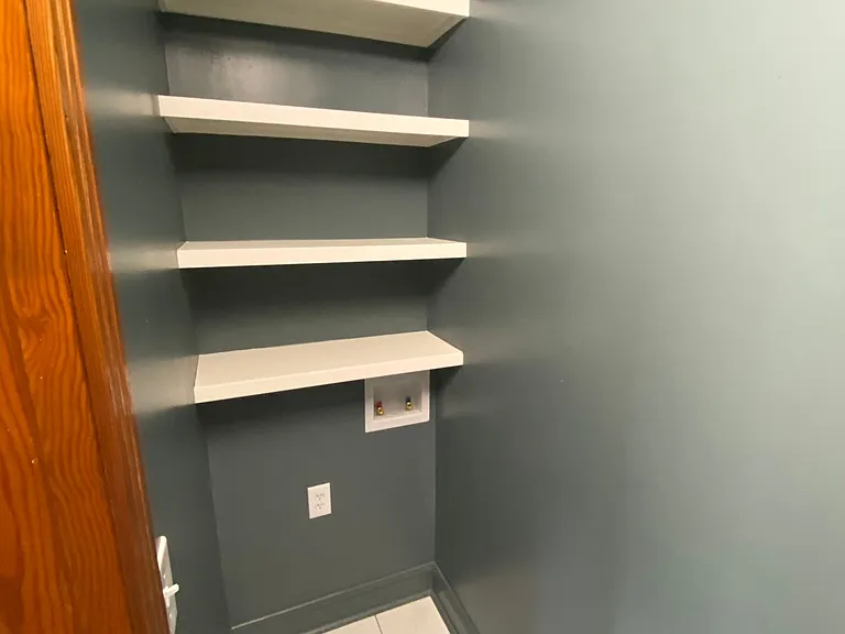 Washer and dryer hook ups with plenty of built in shelving for storage and space for laundry baskets, etc.