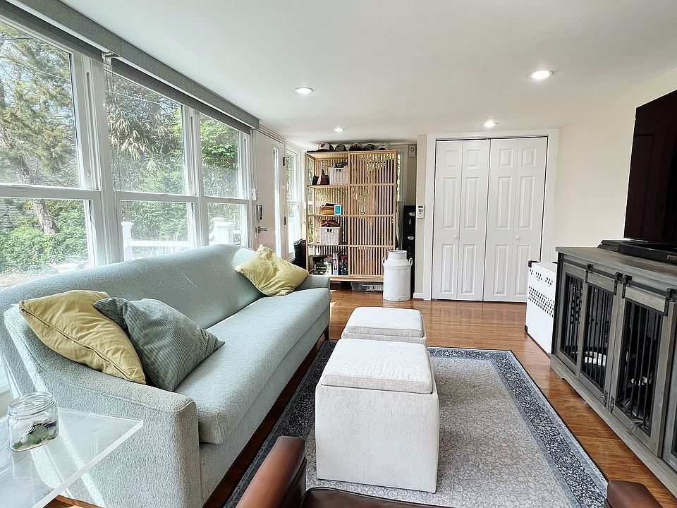 Cozy living room with lots of windows/natural light and a closet with built in shelving