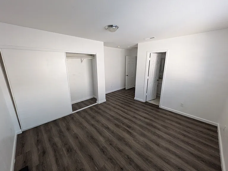 Wide shot of the room showing off the entrance, living space, closet, and entrance to the private full bathroom.