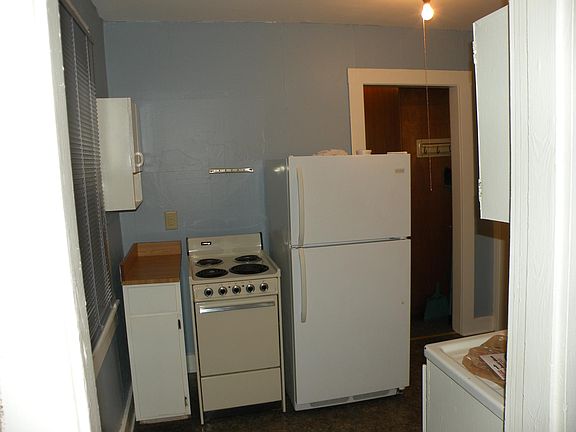 Kitchen is furnished with a small electric stove and fridge.