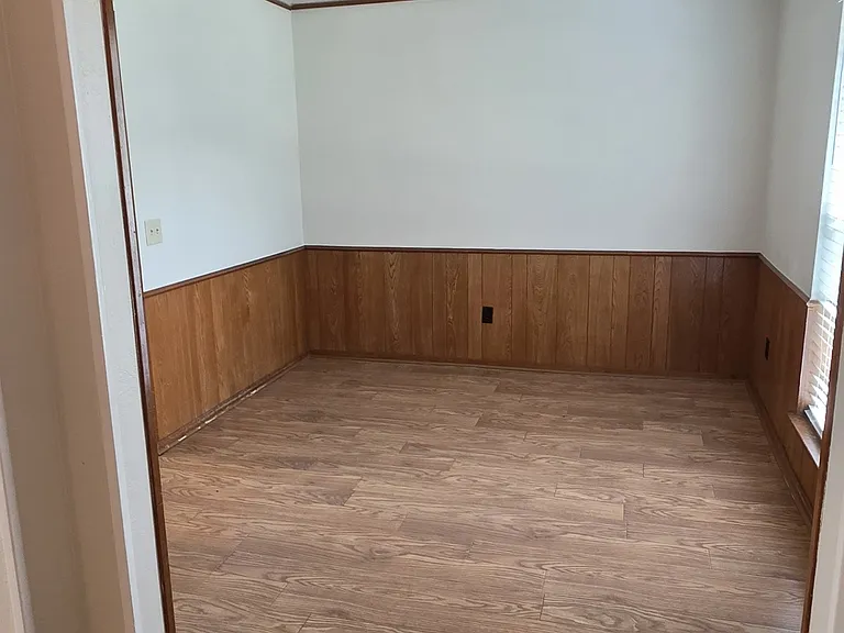 large formal diningroom with engineer flooring, ceiling fan and paneling
