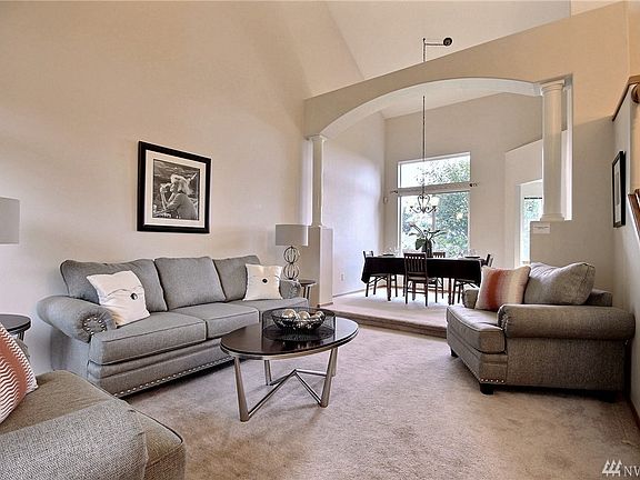 Spacious formal living room with vaulted ceilings & gorgeous archway leading to the formal dining room