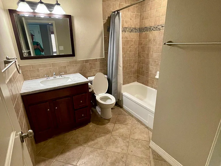 Beautifully tiled large main bathroom with full tub and shower