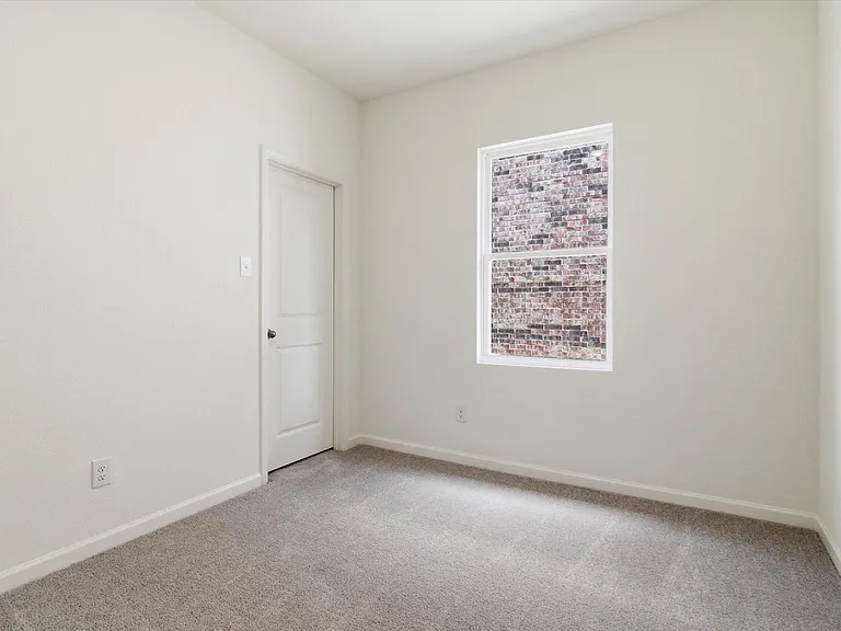 Neutral-toned room featuring light beige walls and a gray carpeted floor