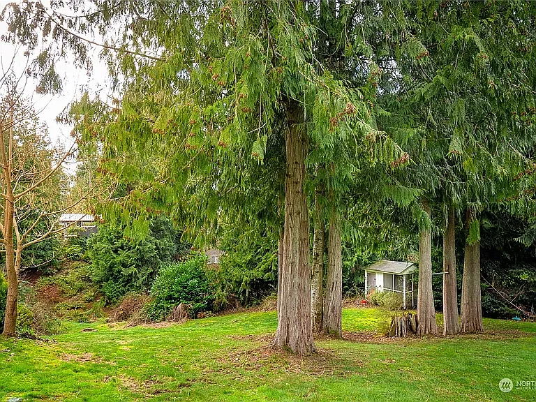 Large yard with several gardens and a chicken coop that lead to a fire pit