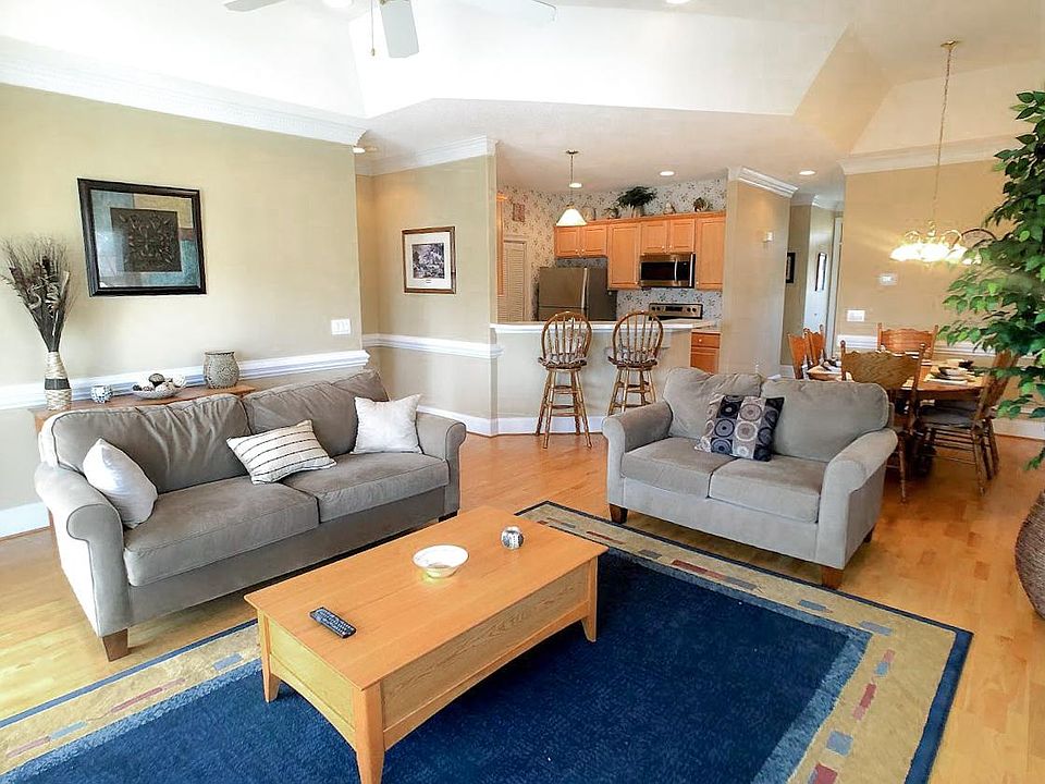 Living room, wood floors, double sliders to balcony overlooking lake and pool