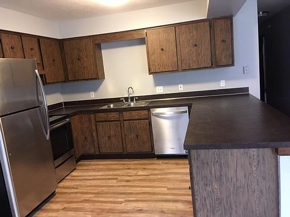 Kitchen sink view with appliances and new flooring throughout.