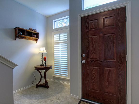 Foyer with slate tile floor, transom window and plantation shutters.