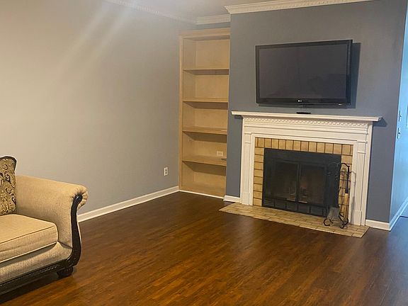 Another view of the living room with laminate flooring and a ceiling fan!
