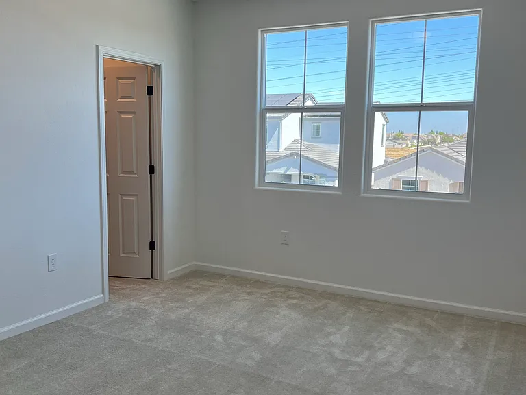 Upstair Bedroom 1: A comfortable, light-filled secondary bedroom with fresh carpet and a peaceful outlook.