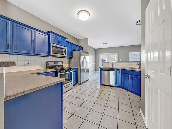 This spacious kitchen is designed with busy families in mind. With tons of storage, stainless steel appliances, and a large walk-in pantry, it offers everything you need to stay organized and efficient. The stunning blue cabinetry adds a cheerful pop of c