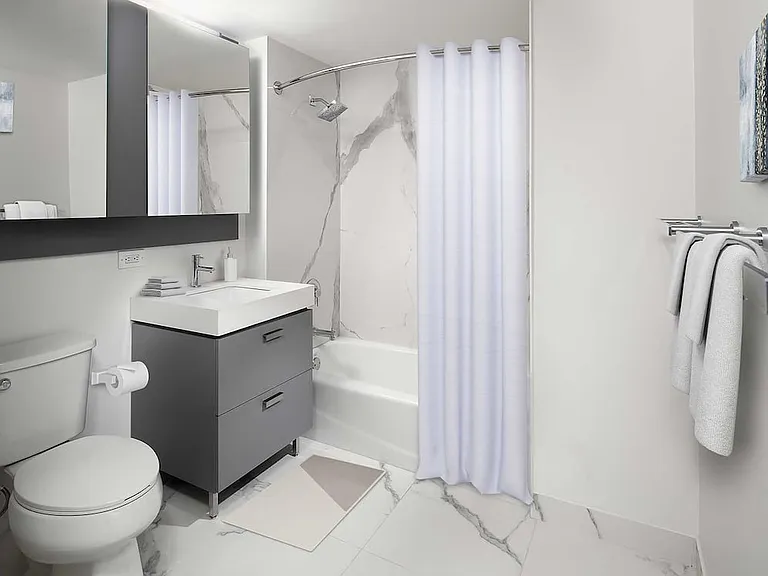 Signature Collection bath with quartz stone countertop and porcelain tub surrounds and flooring