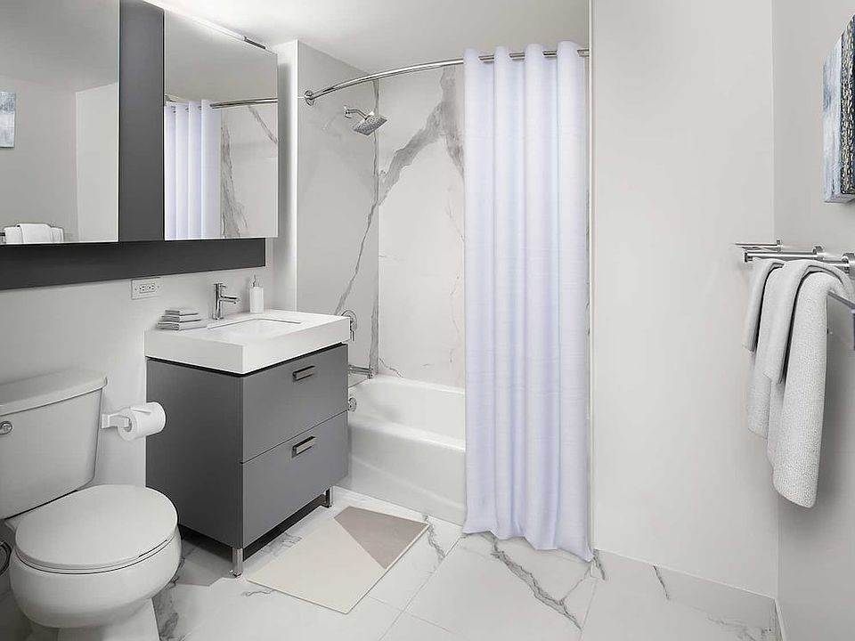 Signature Collection bath with quartz stone countertop and porcelain tub surrounds and flooring