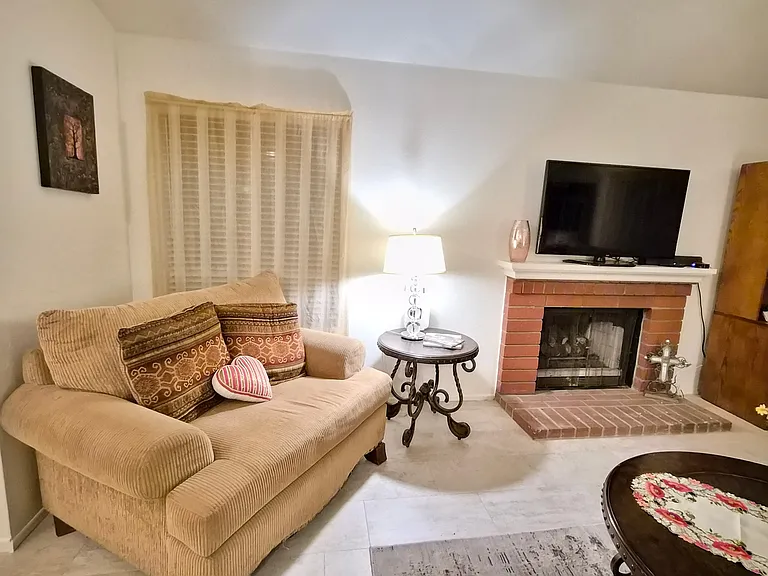 Living room with fireplace, Apple TV, tile floors. Utilities and internet included.