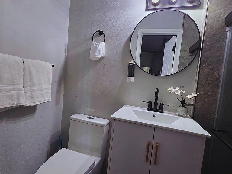 Well-lit bathroom featuring beautiful decor and thoughtful essentials.