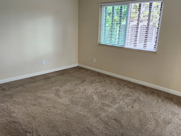 Master bedroom, with ceiling fan and sliding door to patio.