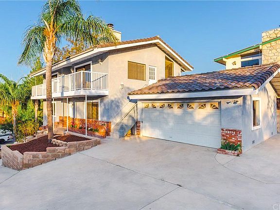 View of the property showing driveway and garage space. And partial backyard view.