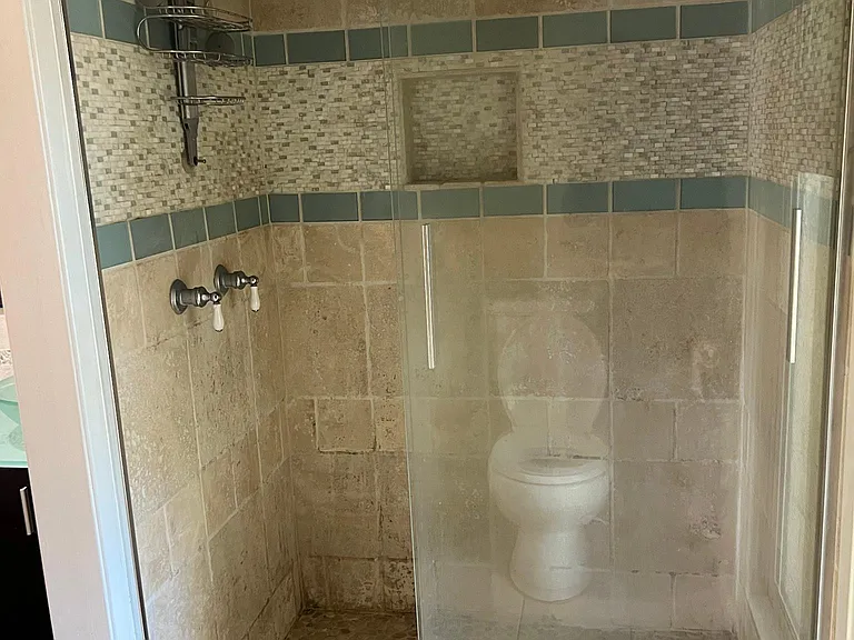 Owner's suite shower with Travertine and glass tiles.