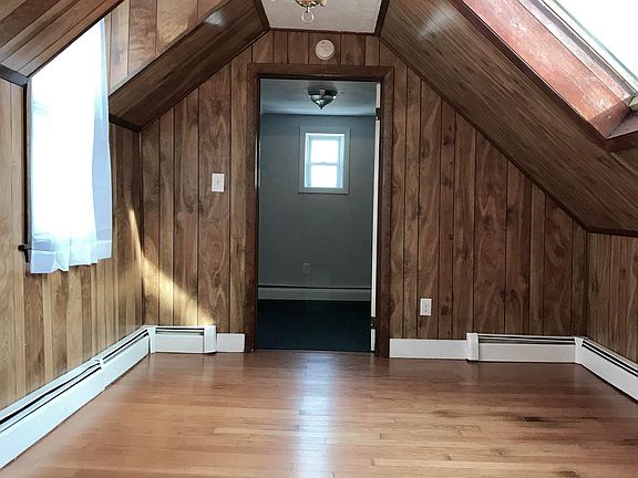 Living room with real wood paneling, large window and large 